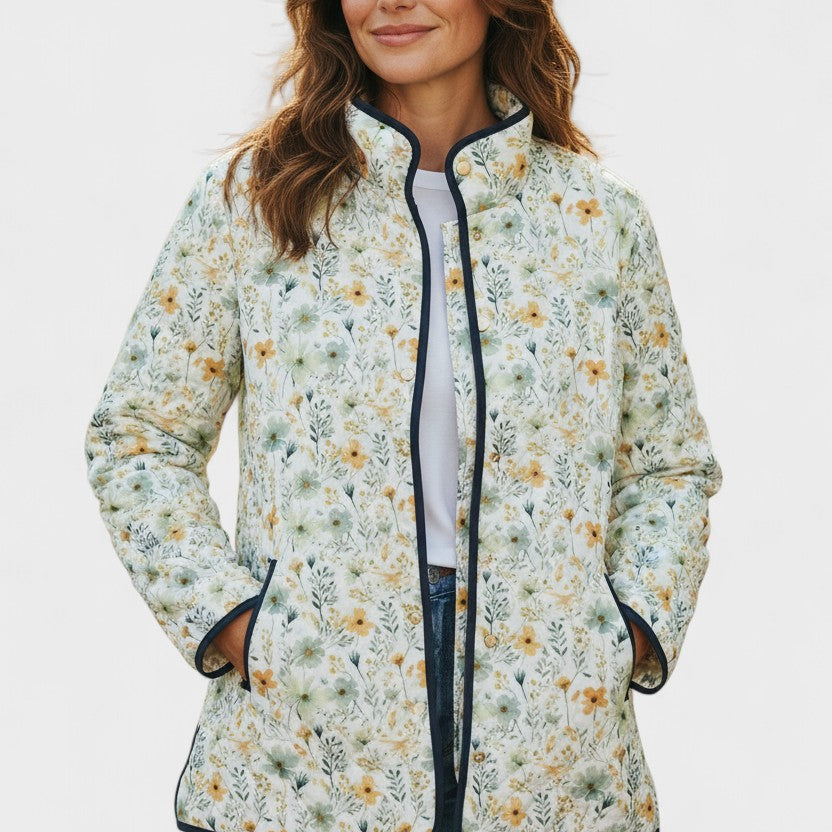 Alma – Steppjacke mit fein verstreuten Blüten auf Cremeweiß und dunklen Abschlüssen als Kontrast – Elara München