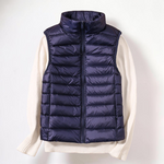 Colete acolchoado azul-marinho Elara München, modelo Roswitha ultraleve com fecho de correr, sobre camisola bege.